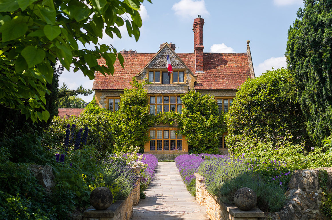 Entrance to grand country home through a flower garden