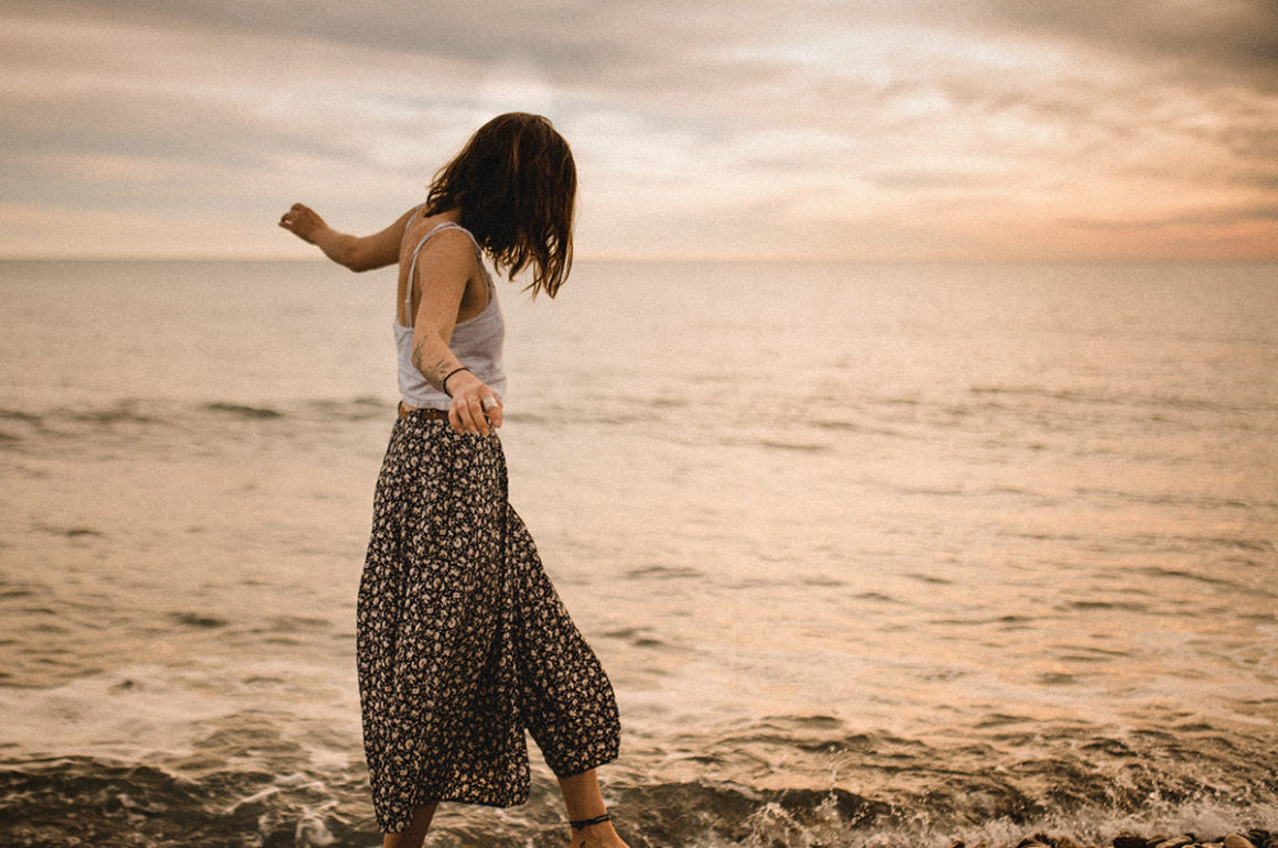 Woman walking bare foot along the beach