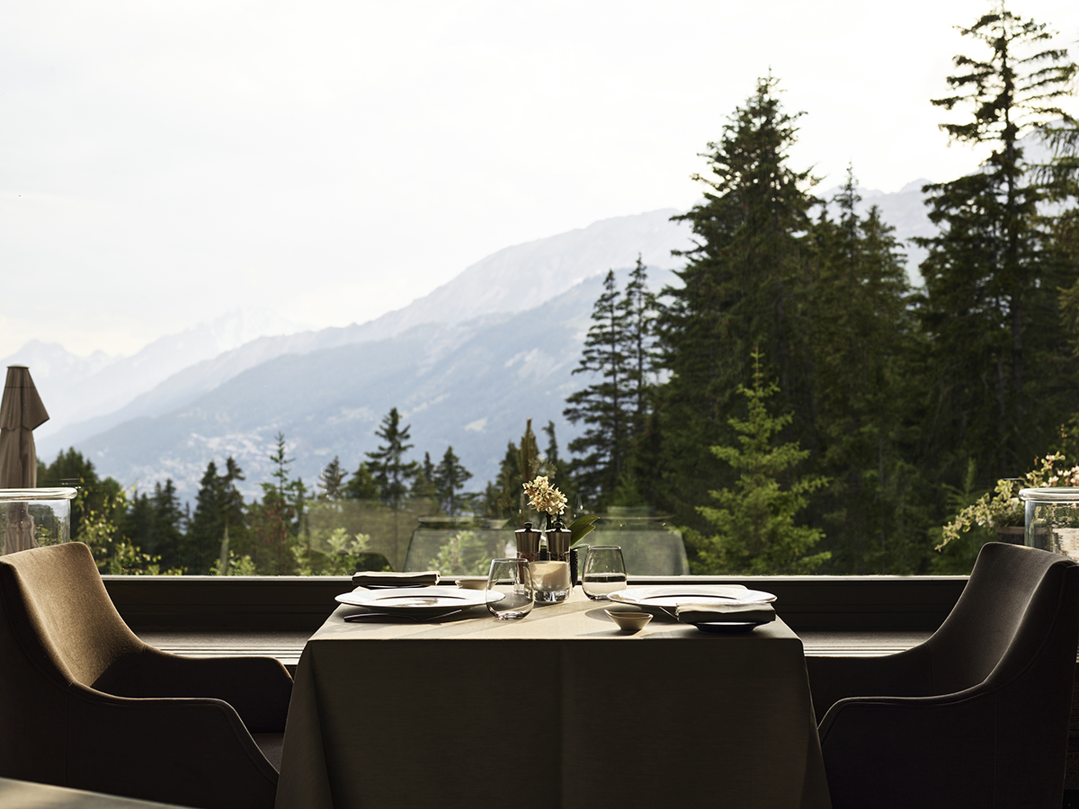 Table by a window with a view of pine trees and mountains