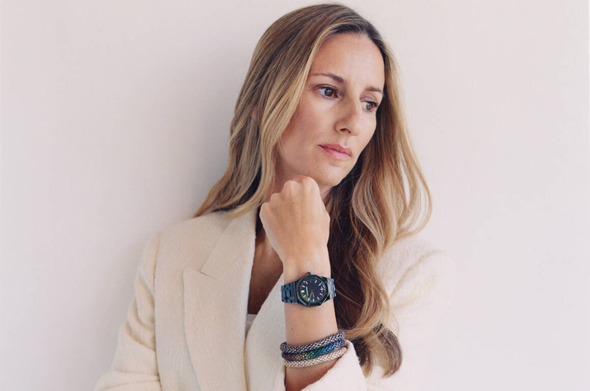 A blonde woman wearing a white jacket and a watch with bracelets