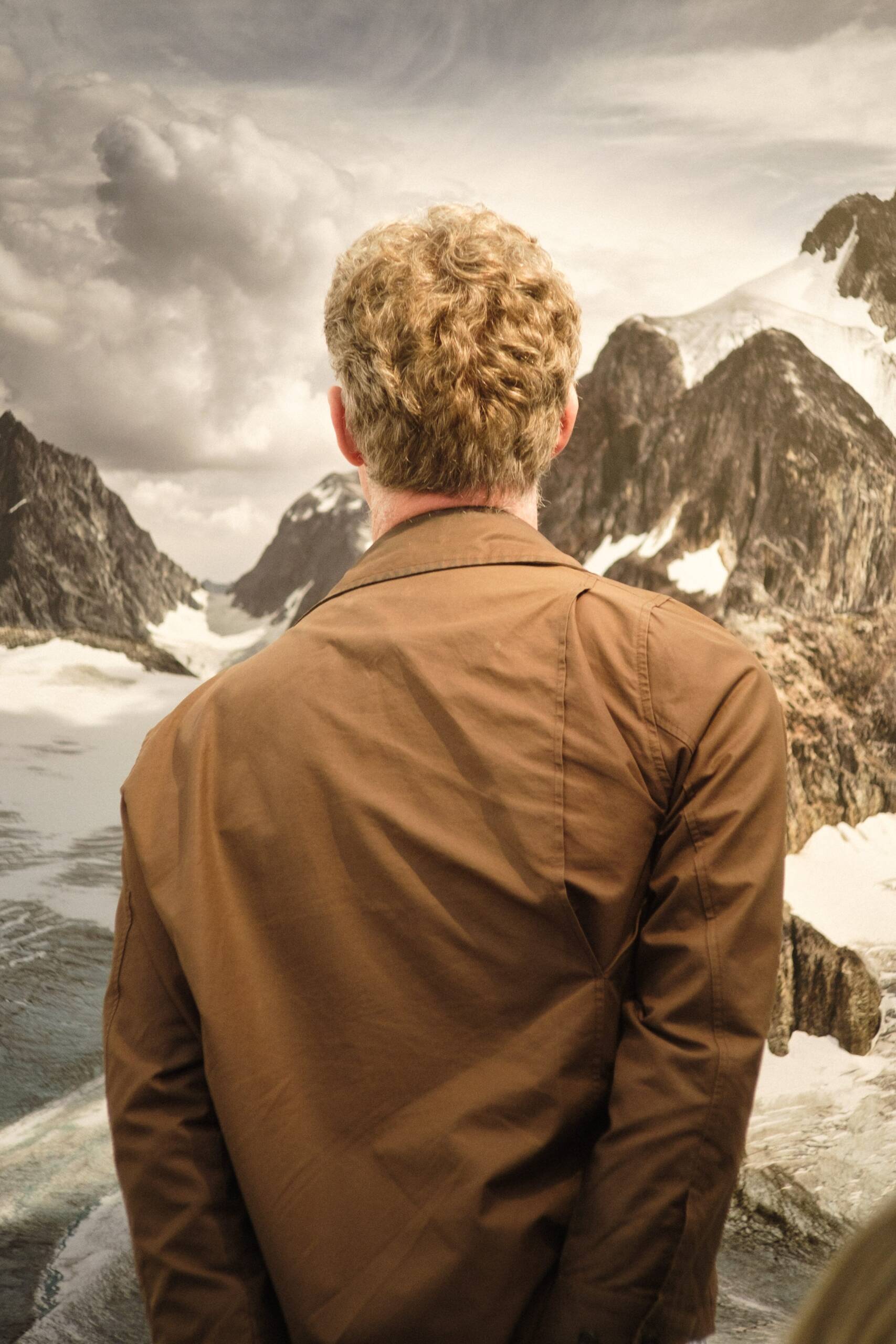 man in front of an image of mountains