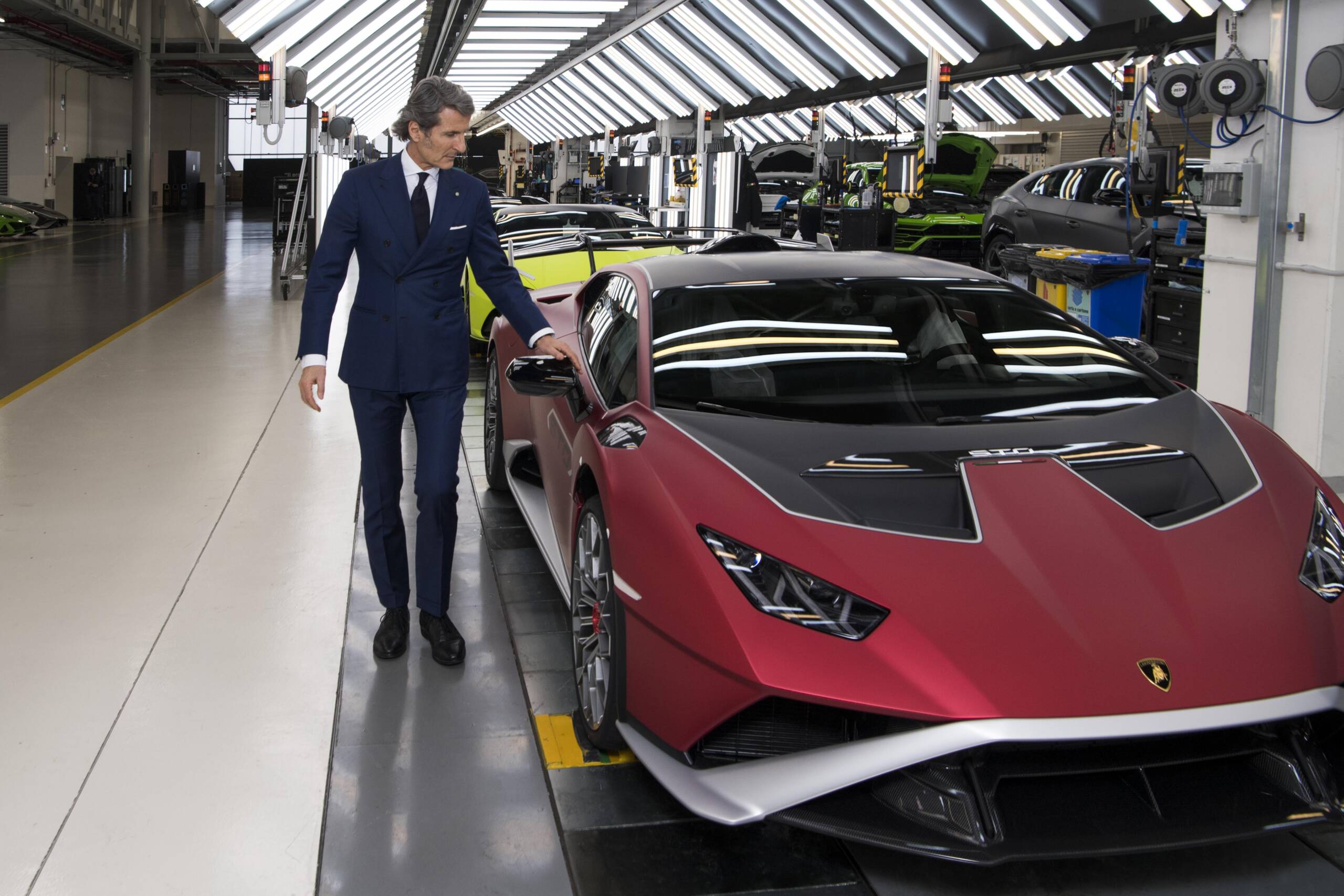 Man in a suit with a red car