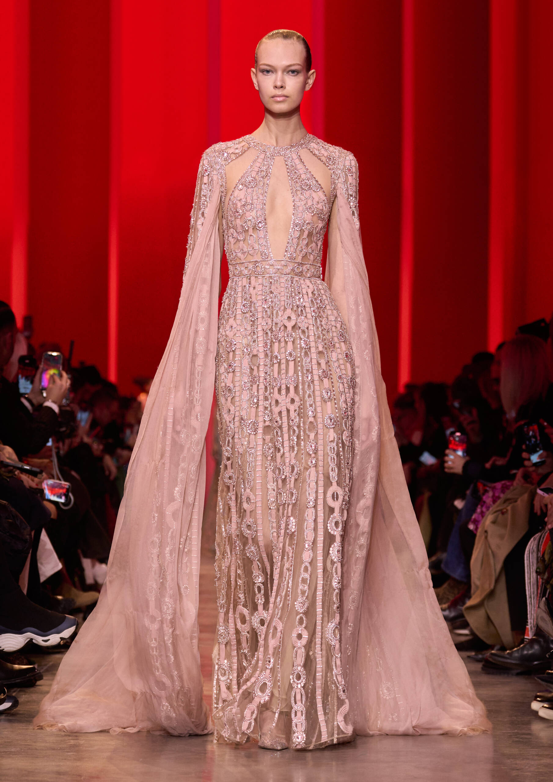 Woman in a pink sequin dress walking down a runway