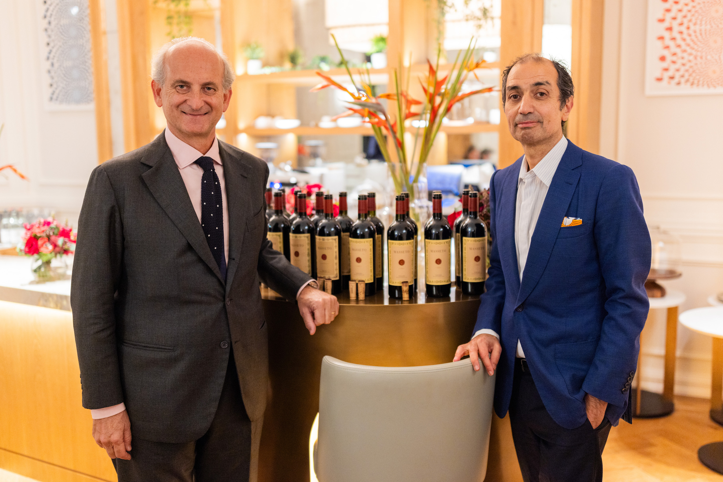 Two men standing in front of wines