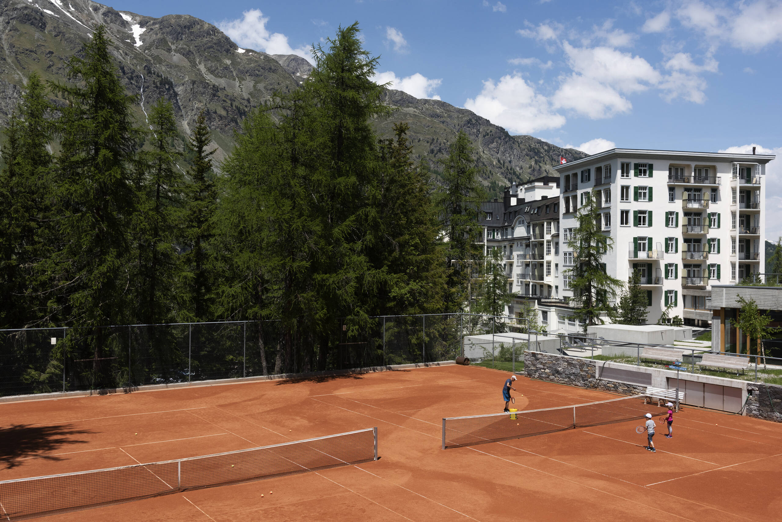 tennis court with trees and mountain behind